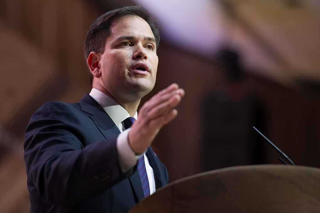 A man in a suit delivering a speech at a podium