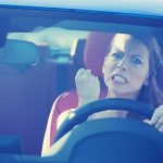 Neighborhood Erupts—Gun Pulled, Kids Caught in Chaos Angry woman gripping the steering wheel in a car