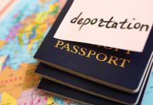 Stack of passports with a note labeled deportation on top, placed on a map