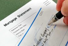 Fed’s Sudden Rate Cut — A Little Too LATE? A person writing a check on a mortgage statement