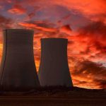 Chernobyl Dogs Turn ELECTRIC BLUE Overnight Silhouette of cooling towers against a vibrant sunset sky