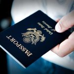 Federal Systems REJECT Valid U.S. Passports A person holding a United States passport with a dark background