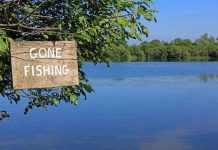 Unbelievable Brawl — Bass Pro Shop’s Mayhem Sign saying Gone Fishing by a lake.