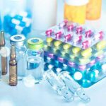 Pharma Boss Collapses—Trump’s Drug Plan Explodes Vials and blister packs of pills on table.