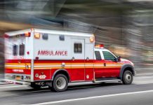ICE Agent SERIOUSLY INJURED in Houston Horror Red and white ambulance driving on street.