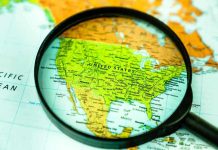 Gen Z Uprising Shakes Mexico City Magnifying glass over United States on map.