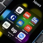 Trump REVOKES Media Licenses — Networks PANIC News app icons on a smartphone screen.