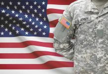 UNPRECEDENTED Military Rebellion Video Goes Viral Soldier in camouflage uniform standing before American flag.