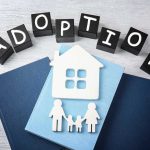 Astounding Neglect: System Misses Dead Child for 4 Years Adoption blocks, books, house, and family paper cutouts.