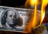$100K Poverty Line? Shocking Debate Ignites Burning hundred-dollar bill with visible flames.