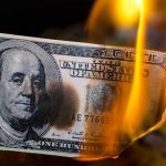 $100K Poverty Line? Shocking Debate Ignites Burning hundred-dollar bill with visible flames.