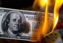 $100K Poverty Line? Shocking Debate Ignites Burning hundred-dollar bill with visible flames.