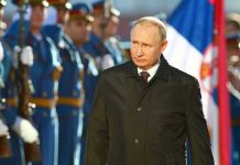 Putin’s Warships INVADE British Waters A man in dark coat at a military event.