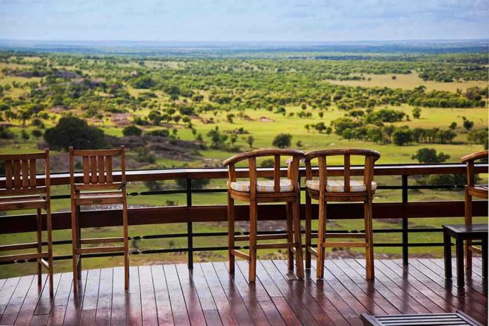 shutterstock_125861735.jpg Outdoor seating area with wooden bar stools overlooking a green landscape