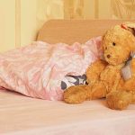 AI Toys Caught Giving Dangerous Advice A cozy bedroom scene featuring a stuffed bunny and pink bedding