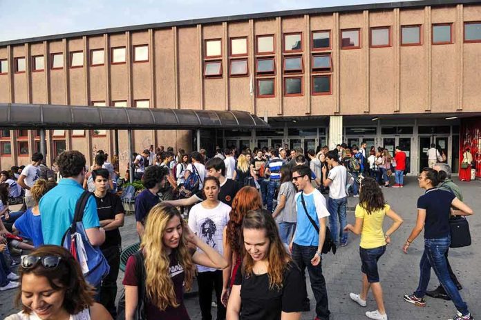 A large group of students socializing outside a school building