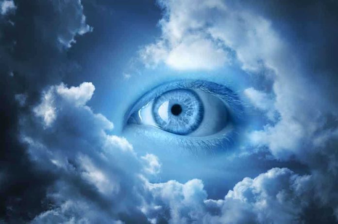 shutterstock_46326091.jpg A large blue eye emerging from a cloudy sky