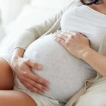 Pregnant Woman MURDERED — Mother Arrested SHOCKING Pregnant woman holding her belly, sitting comfortably.