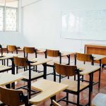 Another School Ignored Warning Signs Empty classroom with desks, chairs, and whiteboard.