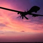 Drones Penetrate Nuclear Base — Nobody Stopped Them Silhouette of a drone against a colorful sunset.
