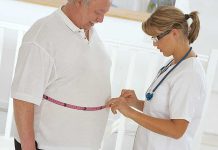 Obesity’s SHOCKING Link to Rapid Alzheimer’s Decline A healthcare professional measuring a patients waist with a tape measure