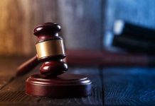 What Courts Are Not Showing the Public Gavel on wooden table in dimly lit room.