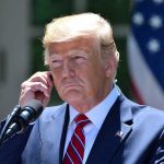 Socialist Mayor Gets White House Win Man in a suit adjusting an earpiece.