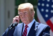 Socialist Mayor Gets White House Win Man in a suit adjusting an earpiece.