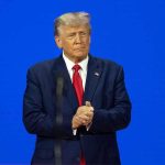 Musk and Trump Reunite Man in a suit with a blue background.