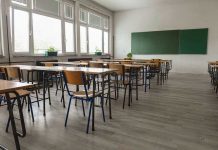 10% Top US Schools From This State Empty classroom with desks, chairs, windows, and chalkboard.