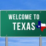 Wake Up Call ISSUED On Texas Welcome to Texas road sign with a Texas map