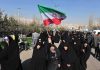 BRUTAL Regime Slaughters Thousands Group of women in black attire marching with an Iranian flag