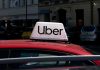 Uber Jury Crushes Contractor Shield Uber sign on top of a red car in an urban setting