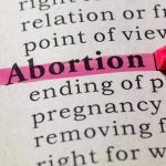 SHOCKING Campus Program TRAINS Teens as Abortion Activists Abortion highlighted in a dictionary with a pink marker.