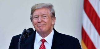 Jon Stewart Praises Trump—Wait, What? Man in suit and tie speaking at podium.