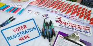 Supreme Court Chaos: Race Map Overturned! Voter registration table with forms, pens, and brochures.