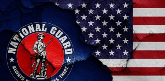 Stunning $50M Fraud: Arrest at Boot Camp National Guard logo over a distressed American flag.