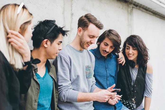 1908675214 Group of friends looking at a smartphone.
