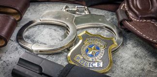 $40M Gold Stash: Top CIA Official ARRESTED Handcuffs, officer badge, and firearm on textured surface.