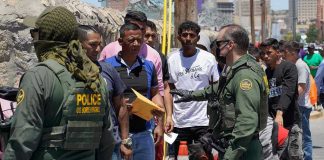 Six Bodies Found: Chilling Border Tragedy Border patrol agents inspecting group of individuals in line.