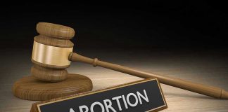 Court OVERRULES FDA on Abortion Pill Safety Gavel and sign reading Abortion on a wooden surface.