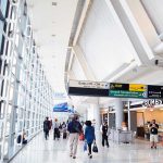 Airport Chaos: Hidden Dangers Exposed! People walking in a brightly lit airport terminal.
