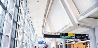 Airport Chaos: Hidden Dangers Exposed! People walking in a brightly lit airport terminal.