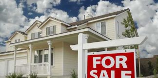 Polis Insurance Claim Shocks Colorado A suburban house with a For Sale sign in the front yard