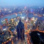 China’s Narrative Game-Changer: Power Beyond Tanks Aerial view of Shanghais skyline at night with illuminated buildings and a river