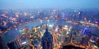 China’s Narrative Game-Changer: Power Beyond Tanks Aerial view of Shanghais skyline at night with illuminated buildings and a river