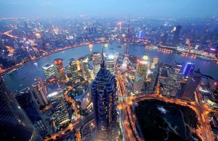 Aerial view of Shanghais skyline at night with illuminated buildings and a river