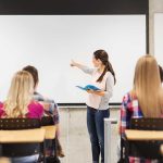 Principal’s Shocking Exit: Protecting Kids or Themselves? A teacher presenting to students in a classroom