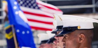 Pentagon Reenlists Marine Hero Marines in uniform standing in formation with flags in the background