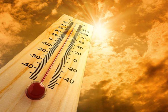 shutterstock_80404600 A thermometer displaying temperature against a sunset sky